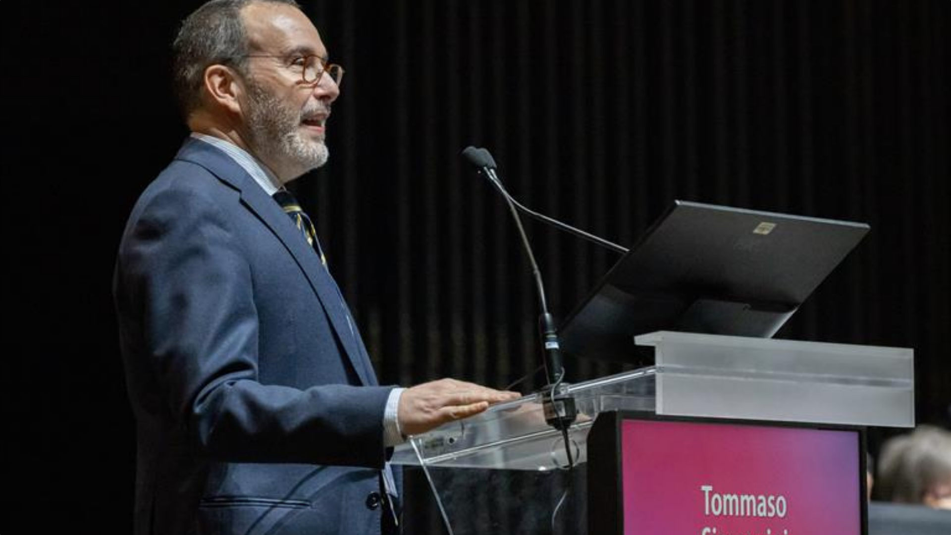 Tommaso Simoncini, President of the International Society of Gynecological Endocrinology, stands at a podium delivering a speech during the ISGE 40th Anniversary Congress in Rome, March 2026. He appears focused and professional, addressing an audience in a conference setting, with event branding visible in the background.